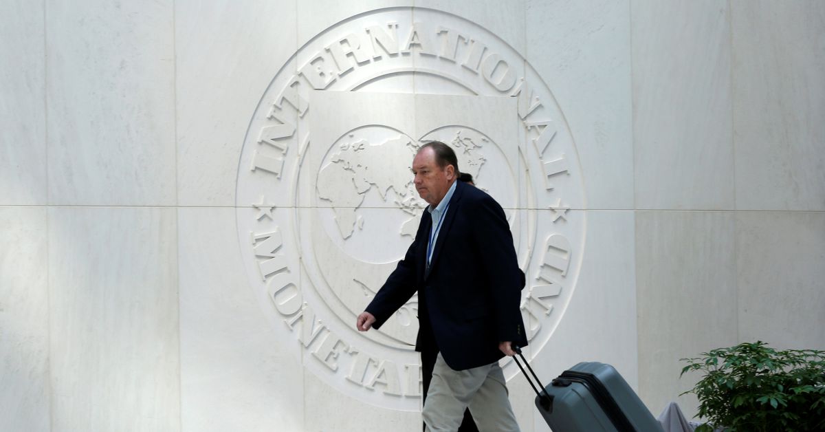 A man walks past International Monetary Fund logo