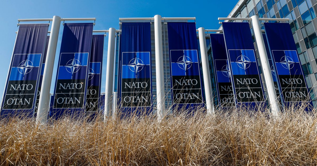 Banners displaying the NATO logo are placed at the entrance of new NATO headquarters during the move to the new building